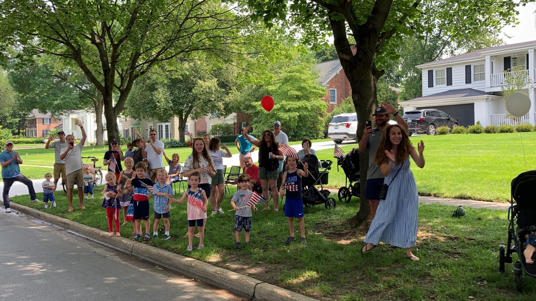 Group of people cheering on parade along Plymouth Avenue